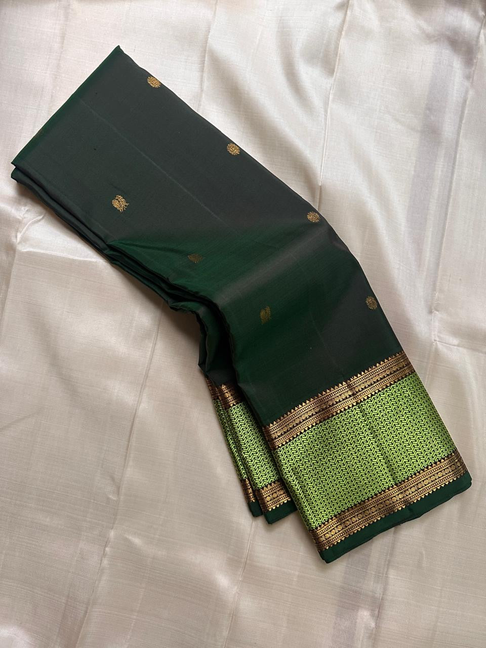 Pachai Maragatham — Pure Kanchipuram Silk Saree
Deep pachai (forest green) body with gold chakram buttas and maragatham chevron zari borders, finished with a coffee-brown brocade pallu.
Silk Mark Certified • Blouse Stitching Available ($30) • Free Shippin