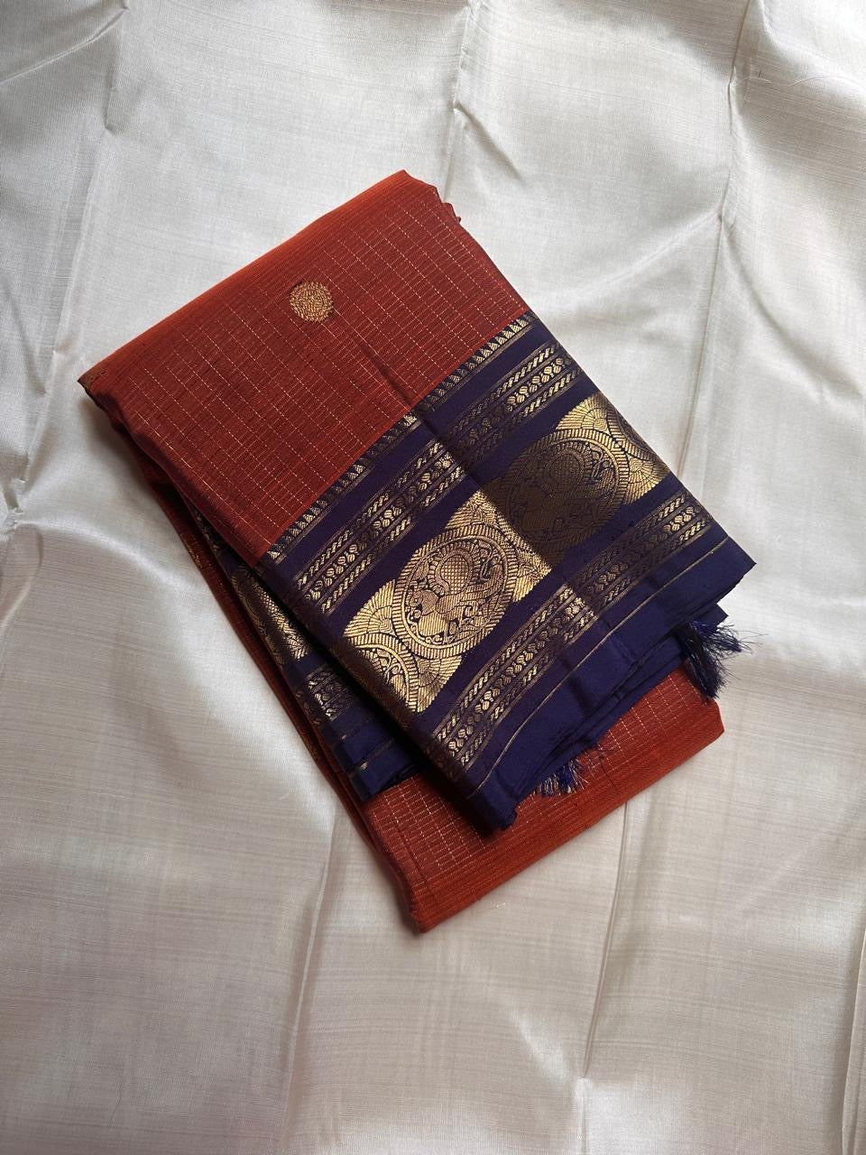 Rust Orange Sorgavasal Mayil – Pure Kanchipuram Silk Saree
Rust Orange Body with Petite Gold Zari Buttas ✨
Grand Navy Border with Sorgavasal mayil Peacock Motifs 🦚
Contrast Pallu in Rich Zari Weave 💫
Silk Mark Certified, delivery in 2 weeks