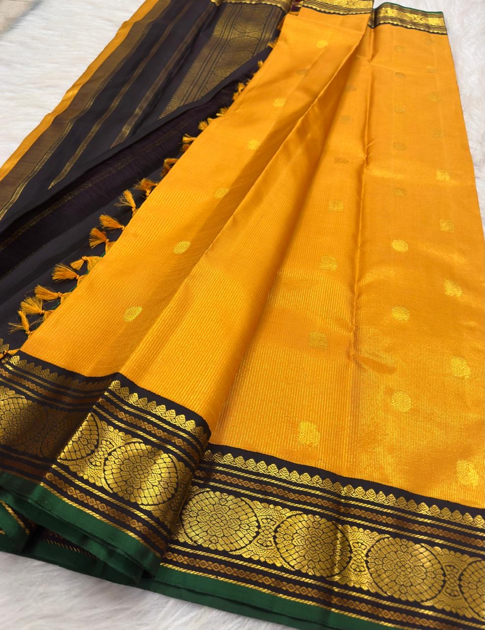 Close view of the deep black Kai Korvai border with gold Kamalam medallions, Malli Moggu ornament and emerald-green edge.
