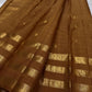 vasantham  Brown– Handwoven Kanchipuram Silk Saree A poem in Brown silk. The body glows in a serene earthy Brown, softly accented by delicate gold vertical lines and dainty gold zari buttas that glint like little blessings.