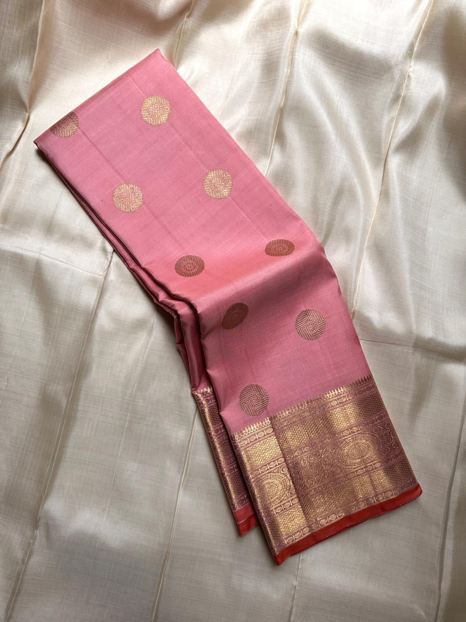 Malini – Pale Pink Pure Silk Kanchipuram Saree with 4G Gold Zari Lotus Buttas and Temple Motif Border
A delicate pale pink drape handwoven in pure silk with shimmering 4G gold zari lotus buttas all over the body.
