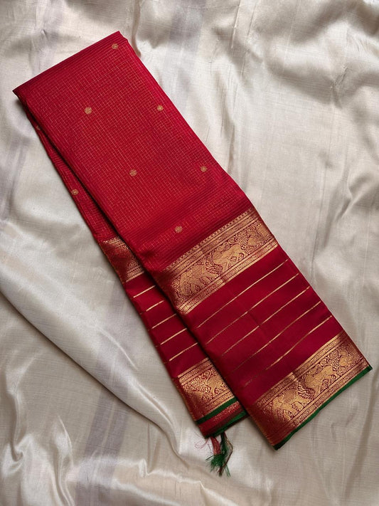 Kiran – Deep Red Kanchipuram Pure Silk Saree
Zari Checks with Delicate Buttas and Striped Rettapet Border
Richly Woven Pallu Accented by a bottle Green Selvedge