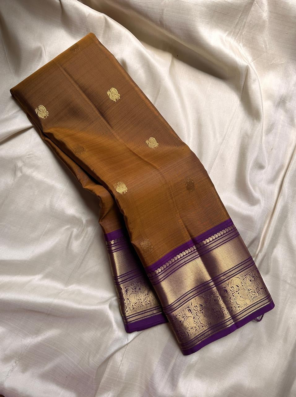 Ponvandu & Purple Butta — Pure Kanchipuram Silk Saree
Antique mustard body with gold zari buttas & rich purple borders
Peacock-woven zari motifs and temple serrations across the grand pallu
Silk Mark Certified • Free Shipping within USA • Ships in Two Wee
