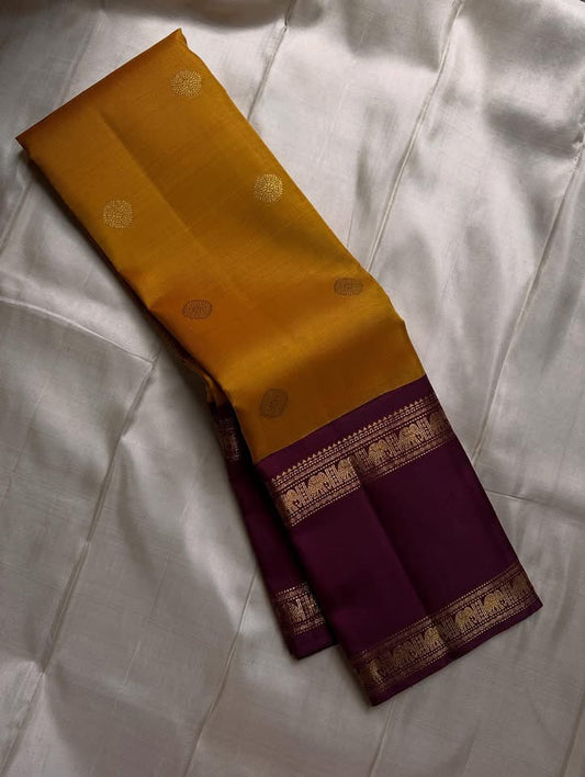 Bhanu – Mustard Gold Handwoven Kanchipuram Silk Saree with Deep Coffee Brown Borders, Intricate Elephant Motif Zari, and a Grand Temple-Inspired Pallu