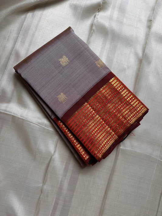 Taupe Glow – Pure Kanchipuram Silk Saree
Ash Taupe Grey Body with Lilac Undertone
Intricate Devadatta Flying Horse Motif in Zari
Deep Maroon Varisaipet Border with Rich Contrast
Grand Zari Pallu with Thazampoo Temple Motifs