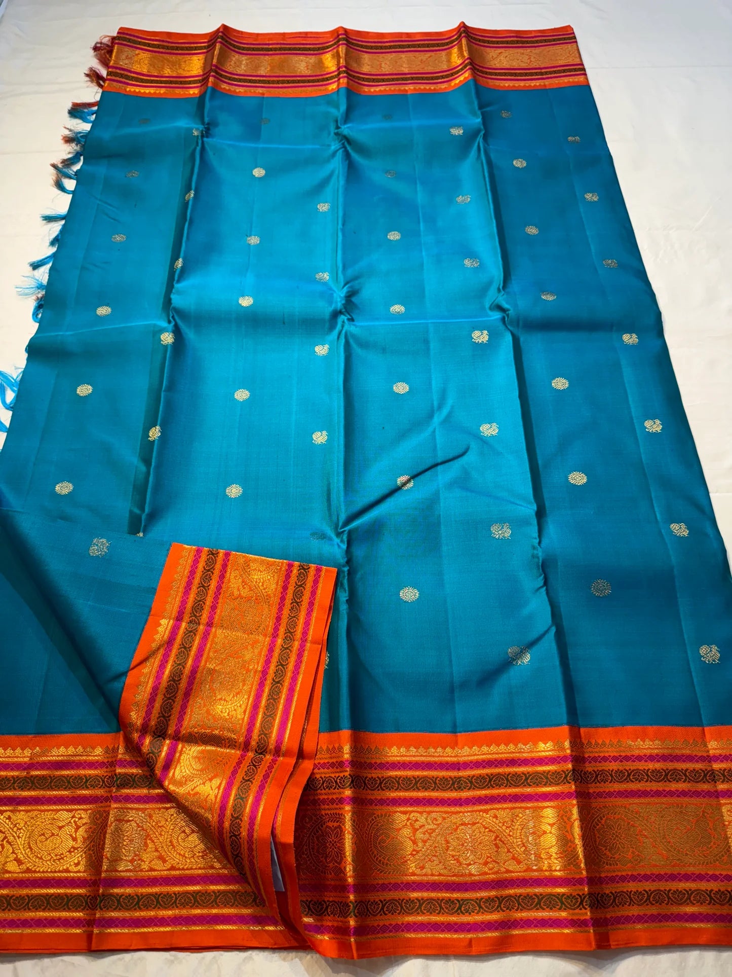 Aazhi Teal — Pure Kanchipuram Silk Saree
Teal body with silver-zari rosette buttas and korvai kavi–magenta borders in gold-zari brocade.
Silk Mark Certified • Free Shipping within USA • Ships in Two Weeks ✅