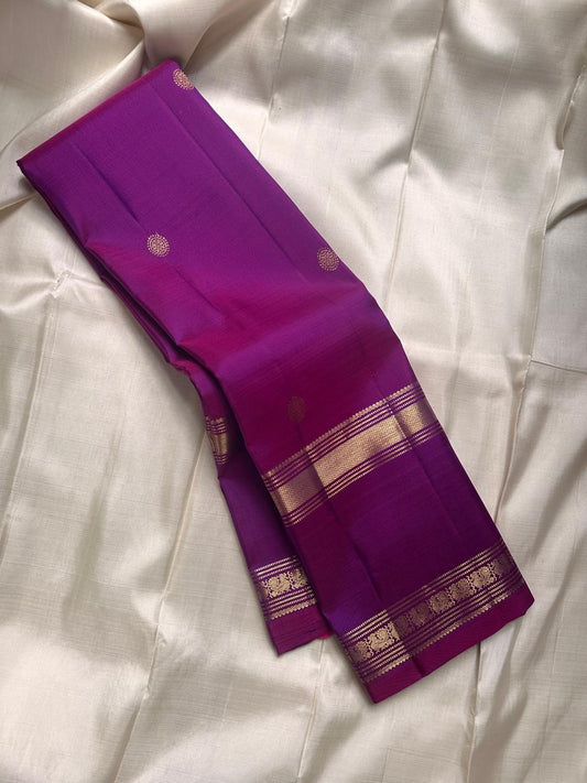 Vadamalli Chakra Butta – Pure Kanchipuram Silk Saree
Regal vadamalli (rani-purple) body with gold zari chakra buttas all over
Triple-line floral zari borders with intricate brocade strip & rich pallu
Silk Mark Certified | ships in 2 weeks
