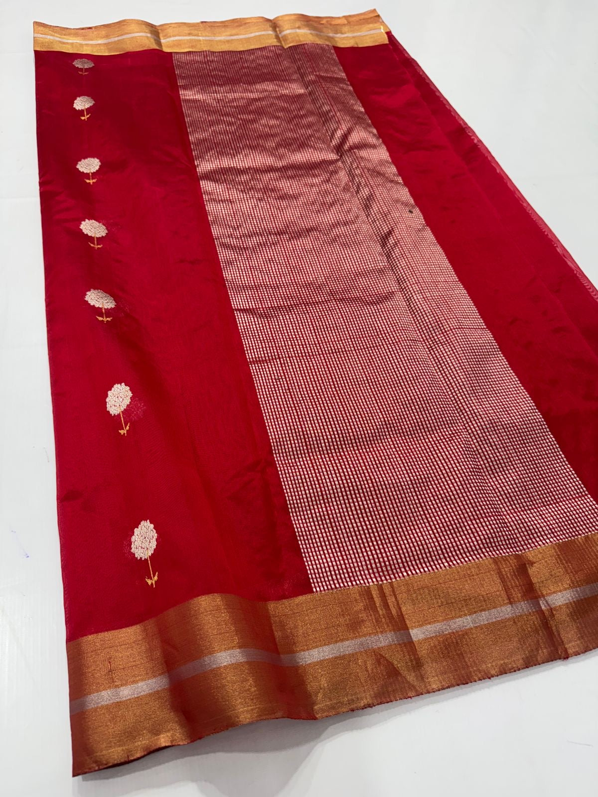 Roja Pushpam — Pure Silk Chanderi (Crimson Blossom)
Crimson red body with silver-ivory floral buttas & gold stems 🌸
Antique copper-gold border • Red-gold tissue pallu • Silk Mark Certified • Free Shipping within USA • Ships in Two Weeks