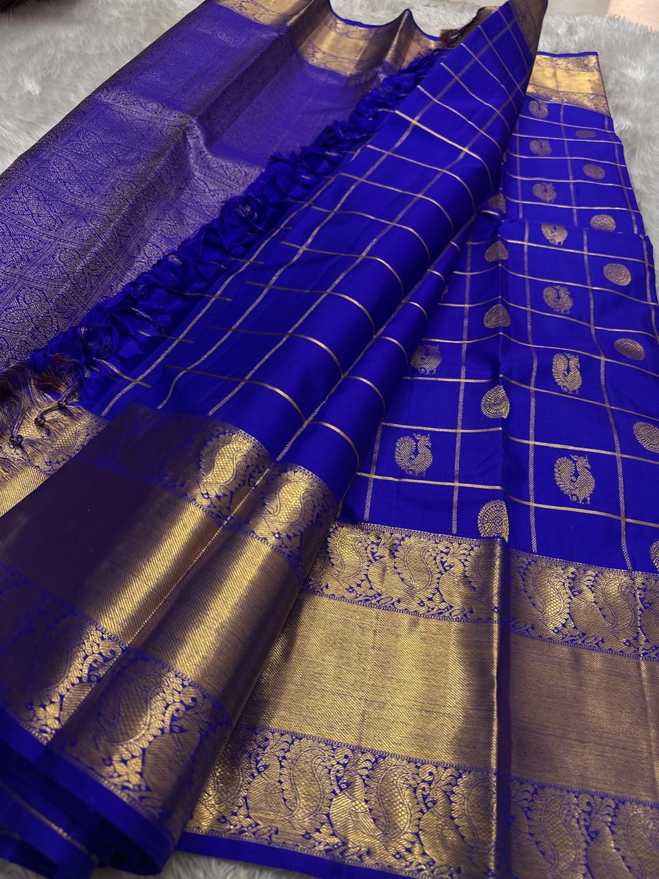 Kalyana Neelam Kattam — Kanchipuram Pure Silk

Deep royal neelam blue body with kattam (grid) checks & mayil buttas

Grand gold kaddi border with ornate paisley vines; rich zari pallu

Silk Mark Certified | Free Shipping within USA

Dispatch in 1 Week