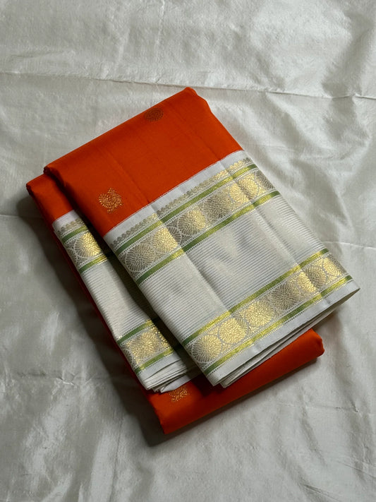 Kesar Chakram – Pure Kanchipuram Silk Saree
Rich Kesar Orange Body with Golden Chakram Buttas
Ivory Korvai Borders with Zari Rosette Motifs & Green Selvedge
Grand Ivory-Gold Brocade Pallu with Orange Tassels
Silk Mark Certified | ships in 2 weeks
