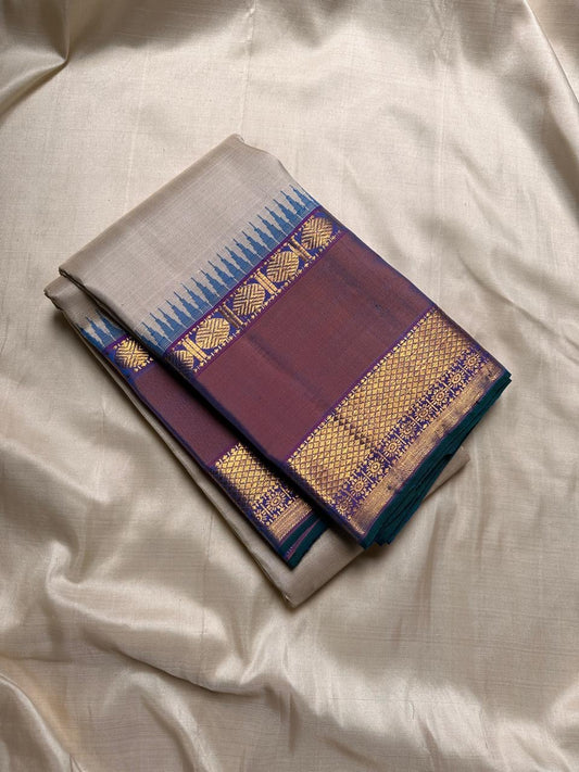 Vaidhehi – Ivory Kanchipuram Silk Saree
A classic ivory silk saree with a shot purple-orange Rudraksham border and a rich Thazhampoo reku pallu—timeless elegance woven with tradition