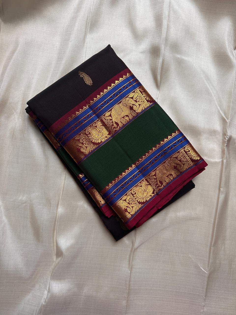 Mahathi Kanjivaram — Black Silk with Elephant Zari Borders
Deep Black Body • Green & Maroon Contrast • Blue Temple Highlights
Silk Mark Certified • Free Shipping within USA • Ships in Two Weeks