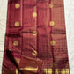 Pavila – Rich brown pure silk Kanchipuram saree in shimmering zari kattam checks. Layered varisaipet borders feature peacocks, yazhi, and rudraksham motifs in ornate zari. A bold broad yazhi adai motif lends ceremonial elegance. Grand  ornate Pallu