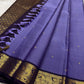 Classic heritage finesse in this lilac blue pure Kanchipuram silk saree Zari kattam , intricately handwoven with fine golden checks across the body. Scattered floral buttas add delicate charm,rich purple peacock border