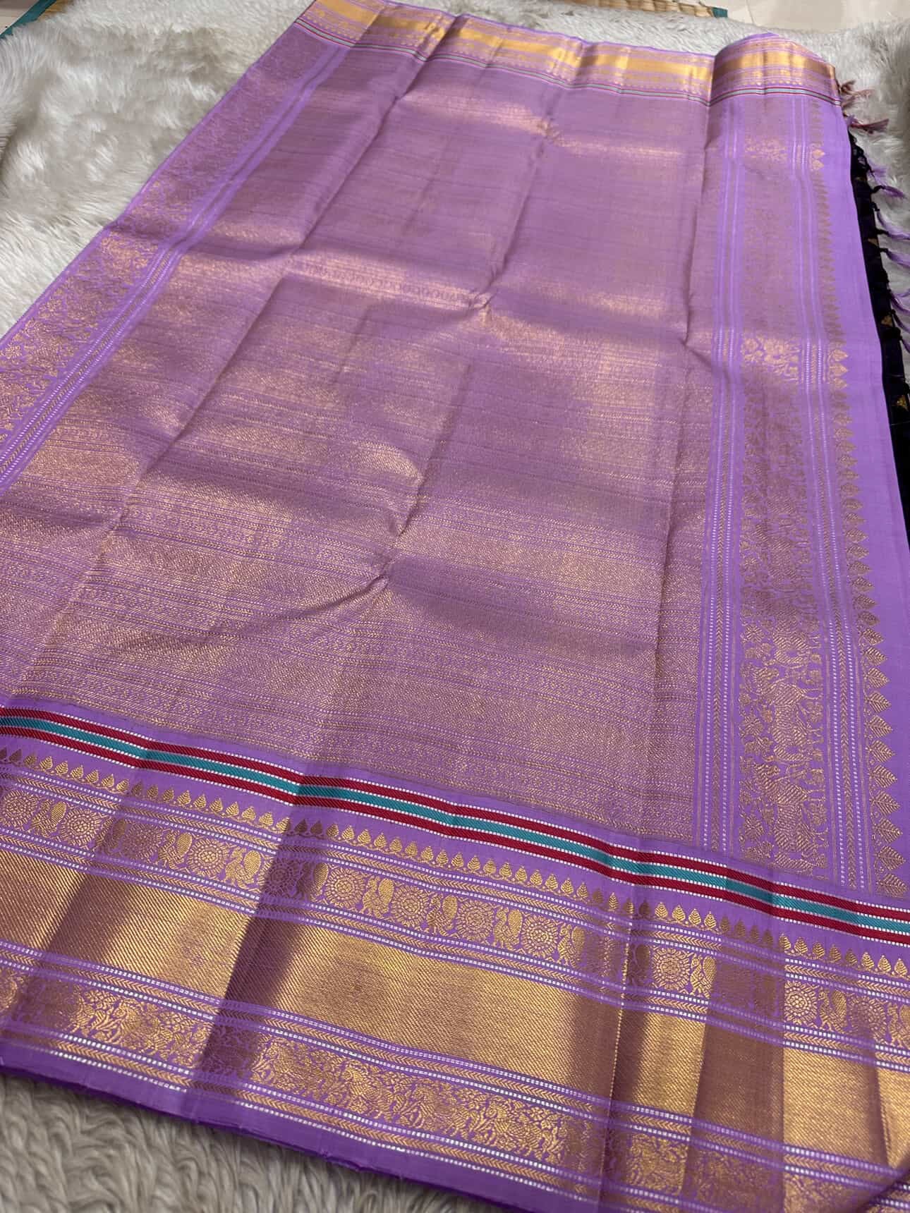 closeup of lavender zari woven border with multicolor stripe on aubergine purple kanchipuram silk saree shipped from New Jersey USA