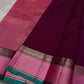 A regal magenta silk with intricate  zari buttas scattered delicately across the body. The border is a stunning blend of soft pink and teal, featuring fine gold silver  zari weaving and temple motifs
