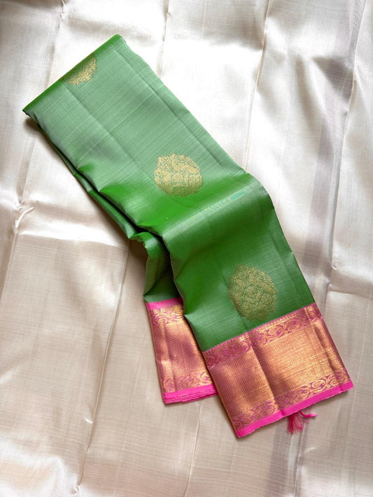Asha ✨ – Fresh Green Pure Silk Kanchipuram Saree
with Radiant Pink Korvai Contrast Border
Gold Zari Floral Medallion Buttas on the Body
Grand Pink Brocade Pallu with Intricate Weaving