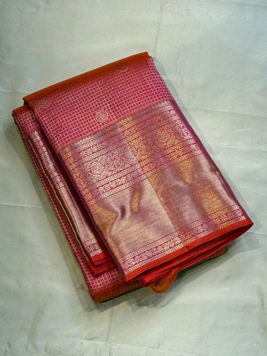 Peach Pink Flower Butta – Coral-pink shot body with micro checks & floral buttas

Handwoven Kanchipuram silk with delicate copper-pink zari work

Elegant floral vines on borders • grand rose-gold brocade pallu

Silk Mark Certified | Fall & Pico Done |