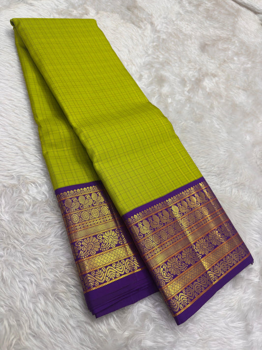 Handwoven Kanjeevaram silk saree featuring antique gold Annapakshi weaving on indigo blue border