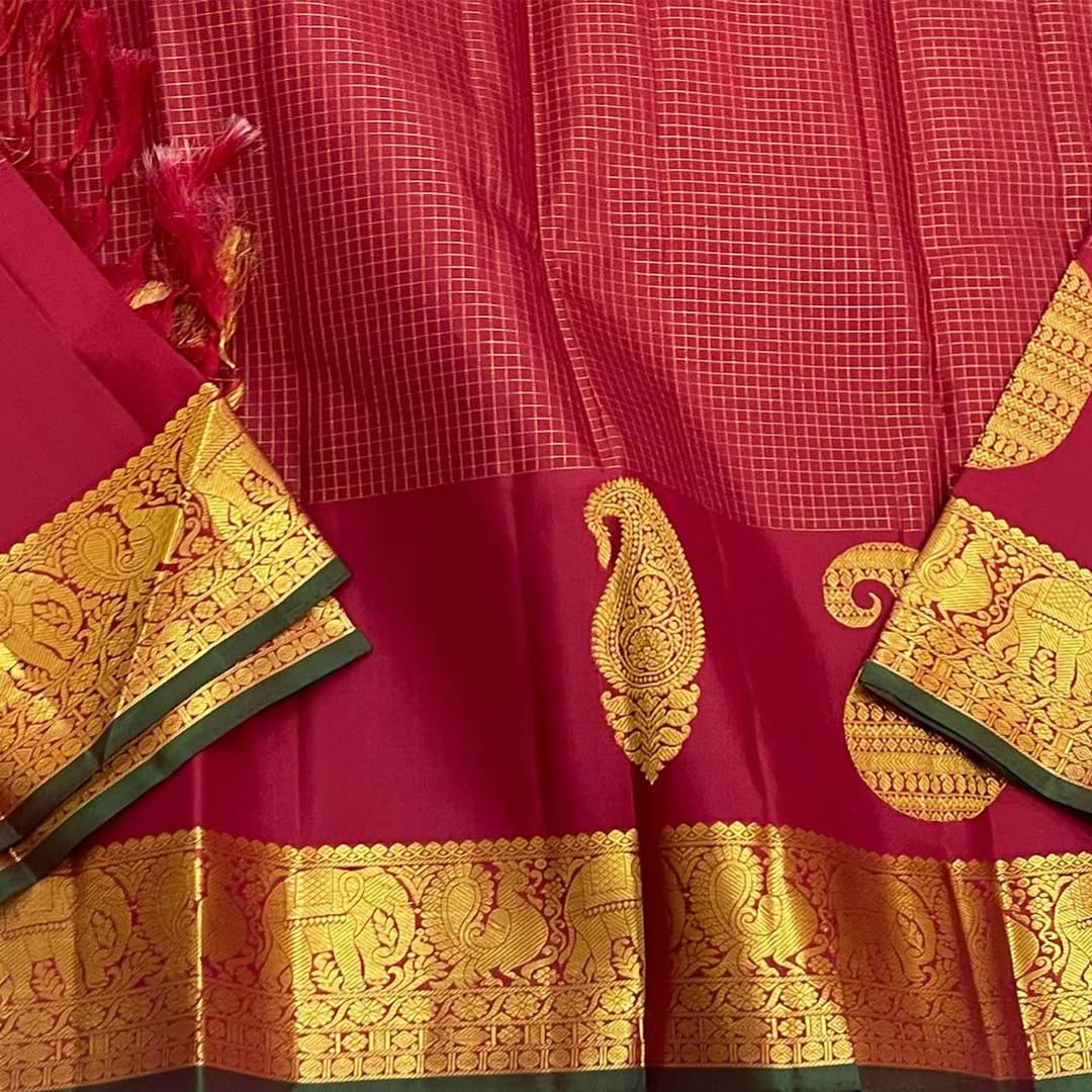 Ushas, Deep Arakku Red Pure Kanchipuram Silk Saree
Radiant Oosi Kattam body with ornate Paisley 2gm Zari
Vanasringaram,Muthuseer,Kamalam border with Fishpettu detailing
Exquisite diamond-pet grid Zari pallu, richly finished with a bold deep green selvedge