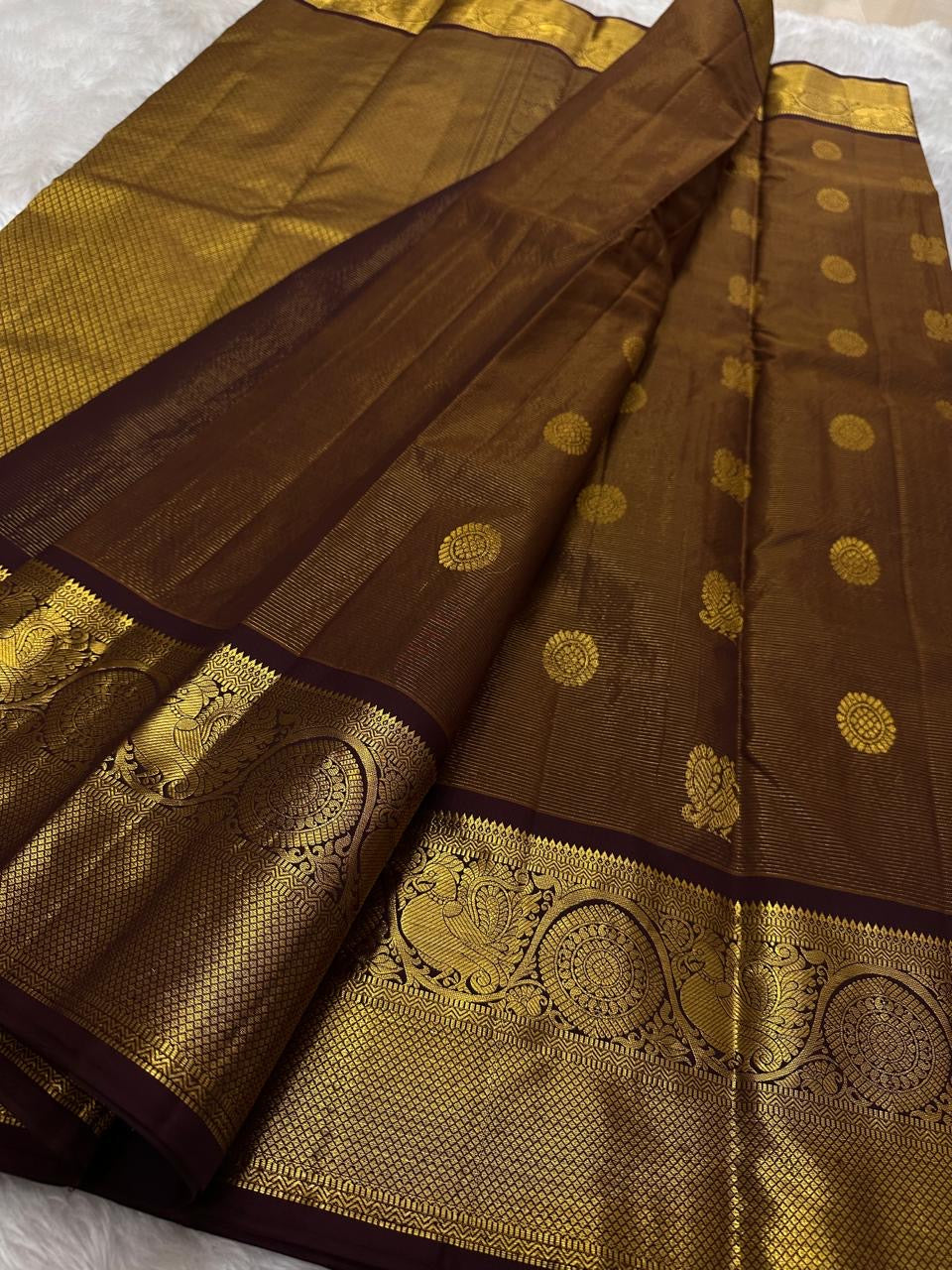Front view of deep rustic brown with a soft petal pink pallu Kanchipuram silk saree with small zari border and rich pallu.