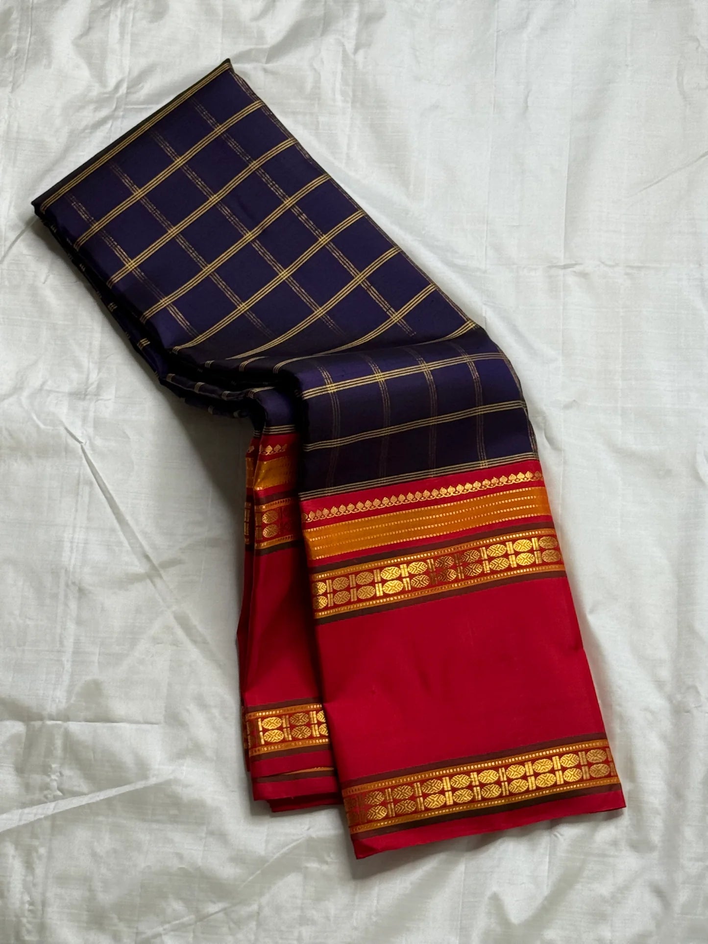 Rani Maragatham Zari Kattam — Pure Silk Kanchipuram (Handloom)
Purple  body with fine gold kattam checks & zari lines • Vibrant vermillion red border with temple coin motifs
Rich red  pallu with antique-gold zari panels • Silk Mark Certified ✅