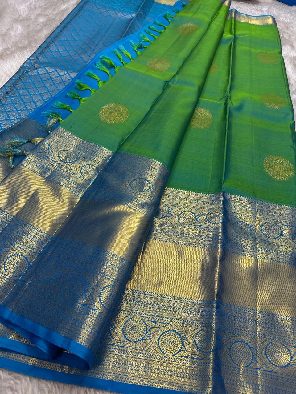 Parrot green Kanchipuram silk saree with gold zari coin buttas, contrast sky blue zari border and pallu