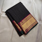 Charcoal Zari Kattam – Pure Kanchipuram Silk Saree
Rich Charcoal Black Body with Gold Zari Checks
Broad Golden Border with Magenta Highlights & Green Selvedge
Royal Magenta Pallu with Lustrous Zari Stripes

Silk Mark Certified, delivery in 2 weeks