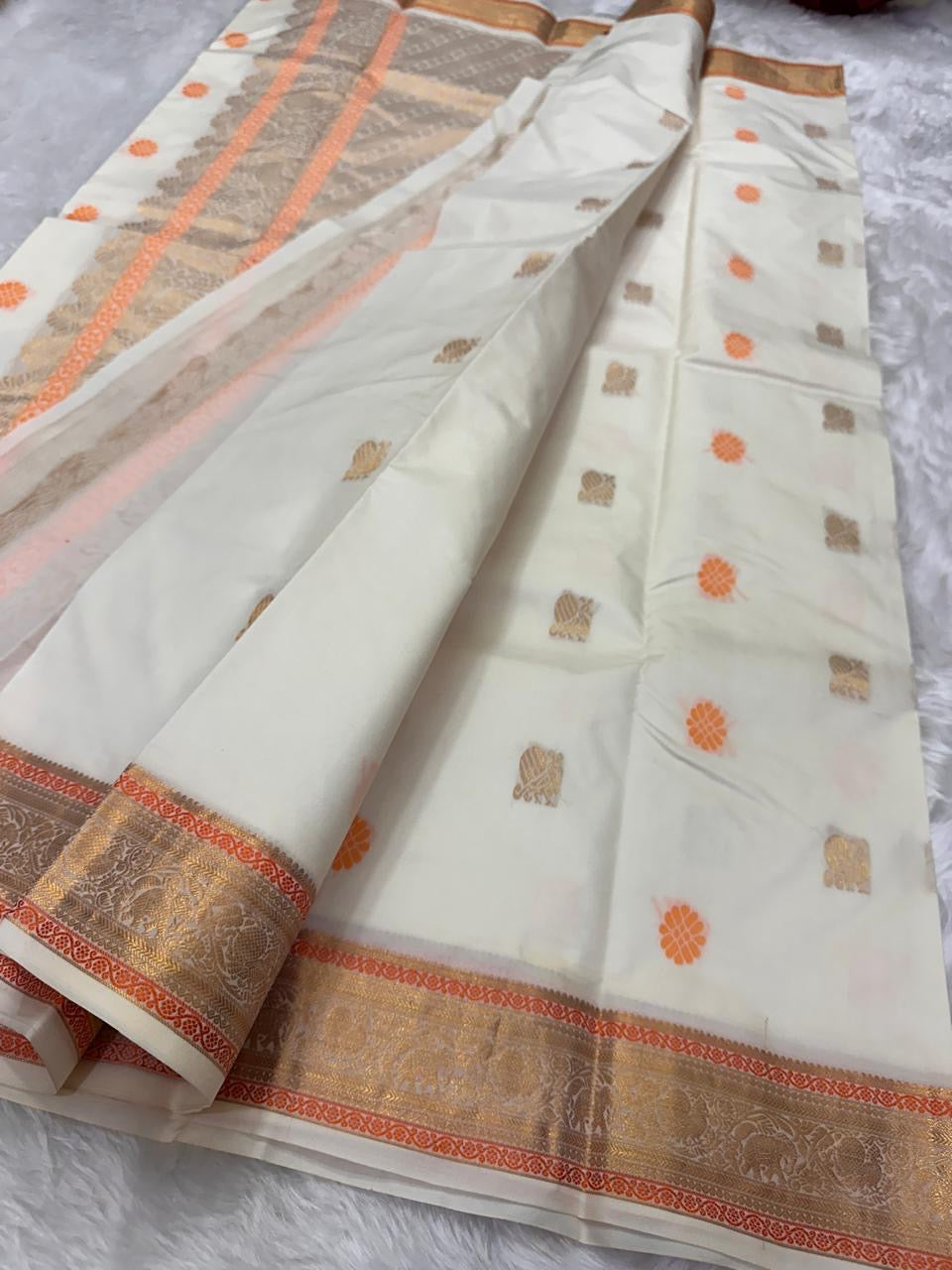Ivory Swarna — Pure Kanchipuram Silk Saree
Ivory body with marigold rosette and antique-gold paisley buttas, framed in champagne-gold elephant brocade borders.
Silk Mark Certified • Free Shipping within USA • Dispatch in 1 Week • Ships in Two Weeks ✅