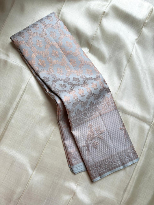 Pakshee 🕊️ – Elegant Kanjivaram Silk Saree
Delicate Ice-Grey Body with Ornate Pakshi Border
Intricate Handloom Detailing & Pure Silk Finish
Celebrate Heritage in Style & Grace