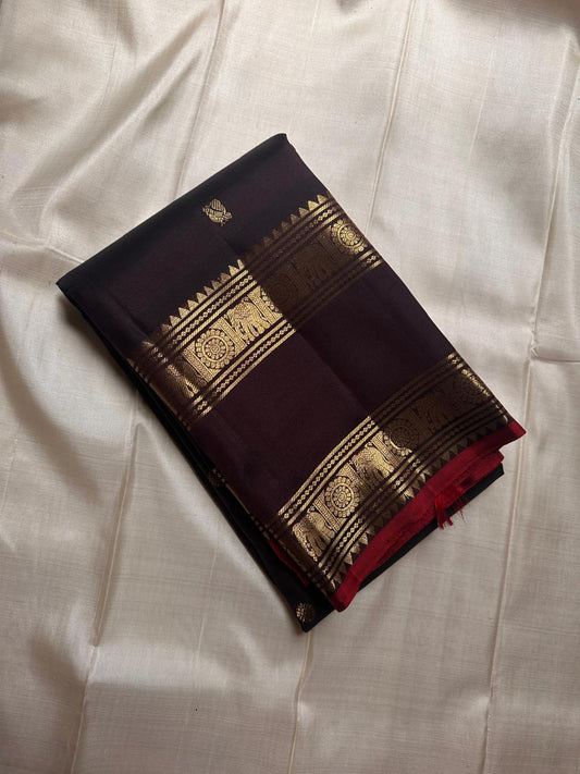 A rare Shot of vermillion and black, shimmers like molten dusk. Rettapet border mayil chakram butta pure silk Kanchipuram saree