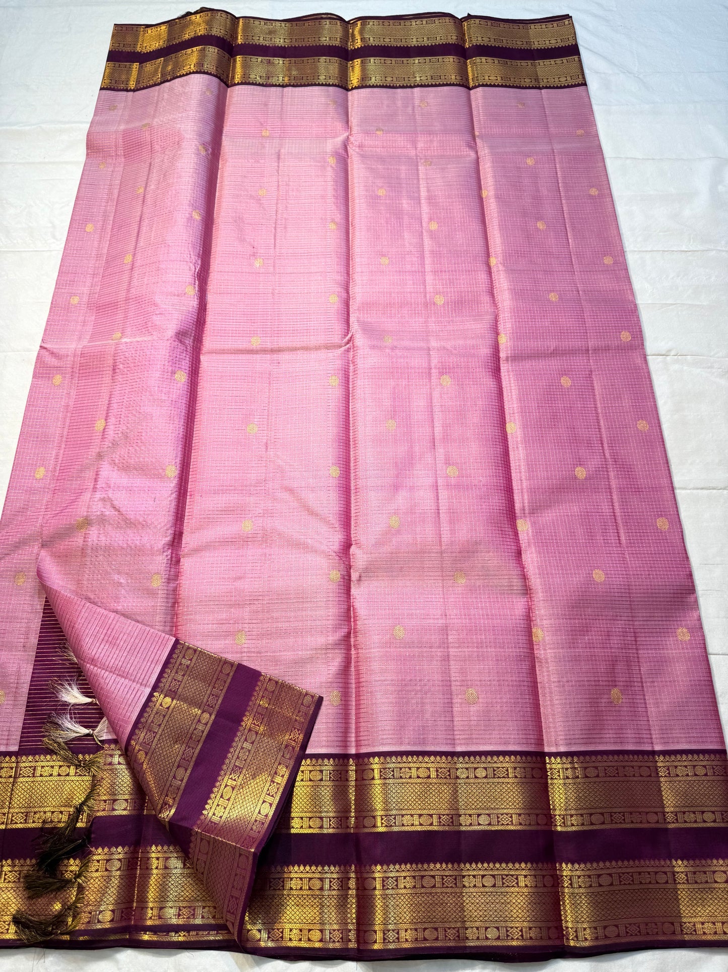 Rose Mist Zari Kattam — Kanchipuram Pure Silk

Blush rose-pink body with micro kattam (checks) in zari & scattered soorya-chakram buttas

Contrast mulberry purple korvai borders with rich gold zari detailing

Free shipping within USA silk mark certified