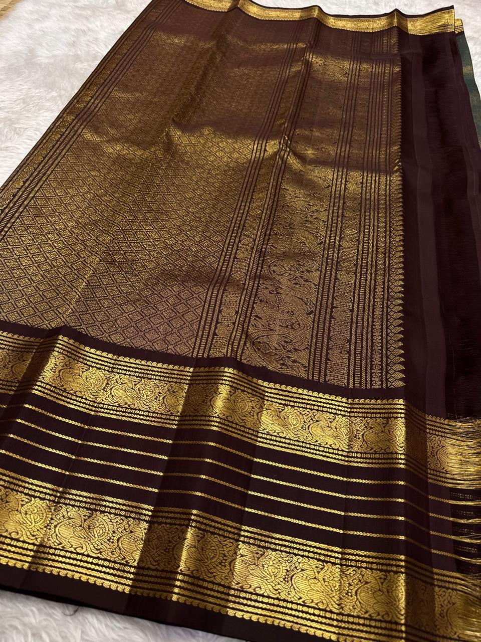 Coffee brown body detail showing the dense diagonal zari weave.