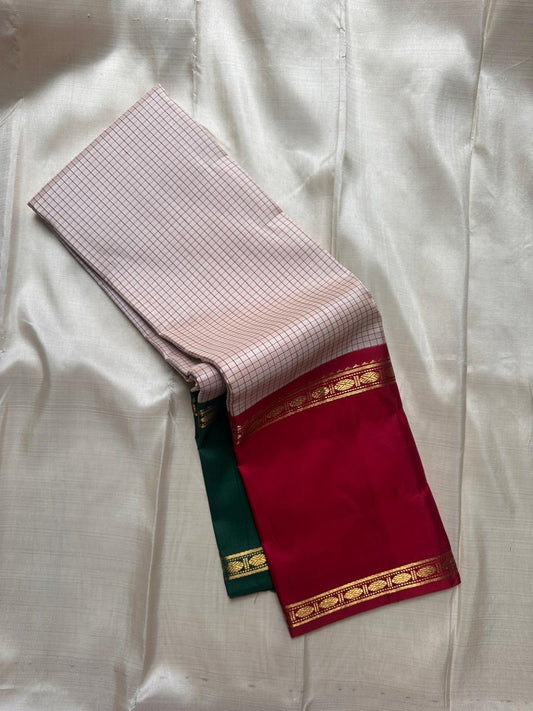 Close view of ivory red checks body with maroon border and gold zari detailing