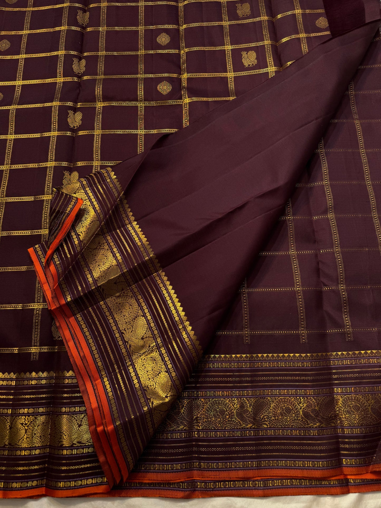Then Thuli — Pure Silk Kanchipuram Saree
Coffee plum with gold kattam checks & mango buttas
Antique-gold peacock borders, brocade pallu, tasselled finish
Silk Mark Certified ✅ • Ships in Two Weeks ✅ • Free USA Shipping ✅