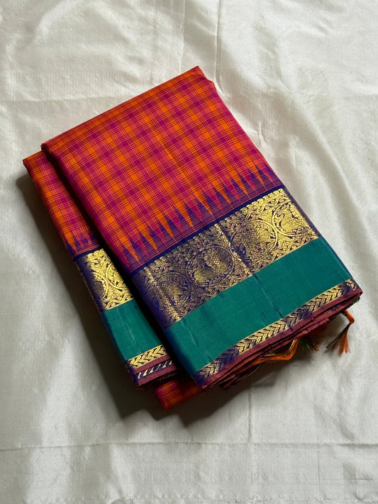 Chemman Maragatha Kattam
Pure Kanchipuram Silk Saree – Reddish-Orange & Maragatha Green Micro Checks
Deep violet korvai borders with gold zari floral motifs
Grand zari pallu with classic brocade detailing
Silk mark certified, ships in 2 weeks