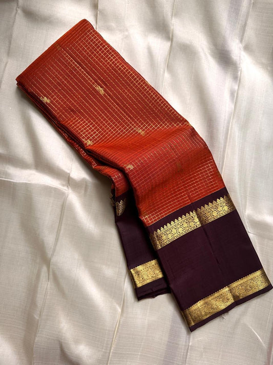 Gilded Rust Kattam – Pure Silk Kanchipuram Saree

Rust-orange kattam (checks) body with petite zari buttas ✨
Deep brown  korvai border with intricate gold zari design 🌸
Grand zari-rich pallu 💛
Silk Mark Certified ✅ | ships in two weeks