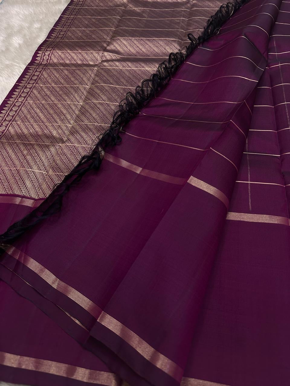 Close view of zari-woven pallu panel with intricate diagonal texture and border detailing on a plum Pure Kanchipuram silk saree.