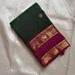 Emerald green silk saree fold with gold zari buttas and magenta border with woven zari panels