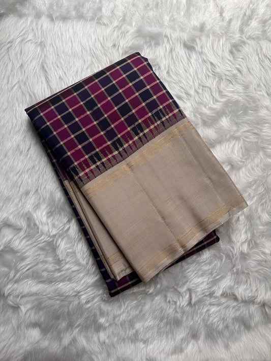 Nirai Navy - A Jewel Toned Checkered pure silk Kanchipuram saree in navy, purple, magenta, and grey checks.Accented with a soft silver-grey border and zari-striped seer pallu
Includes a silver blouse fabric with gold zari stripes