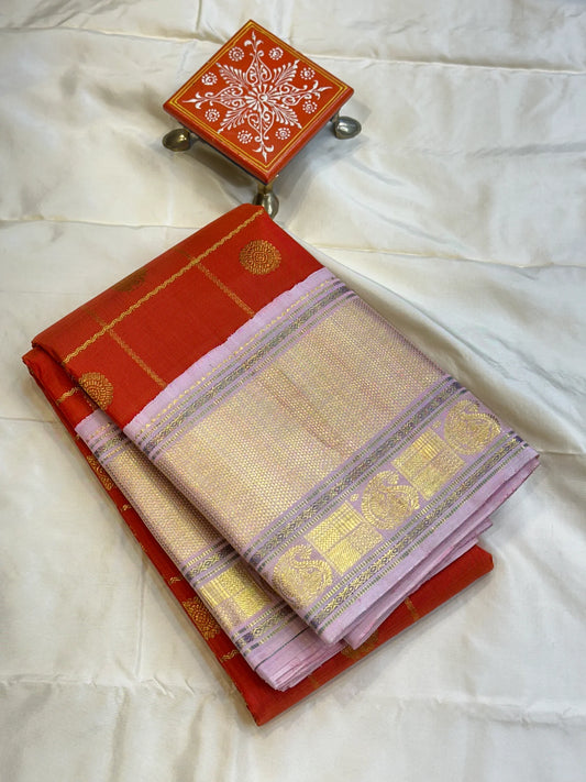 Bhargavi
Striking Orange Kanchipuram Silk Saree with Unusual Lavender Border 💜
Zari Kattam Neli Checks with Kamalam & Mayil Motifs Across the Body 🪷🦚
Broad Arai Maadam Border Flanked by Diamond & Paisley Motifs, Grand Zari Pallu ✨