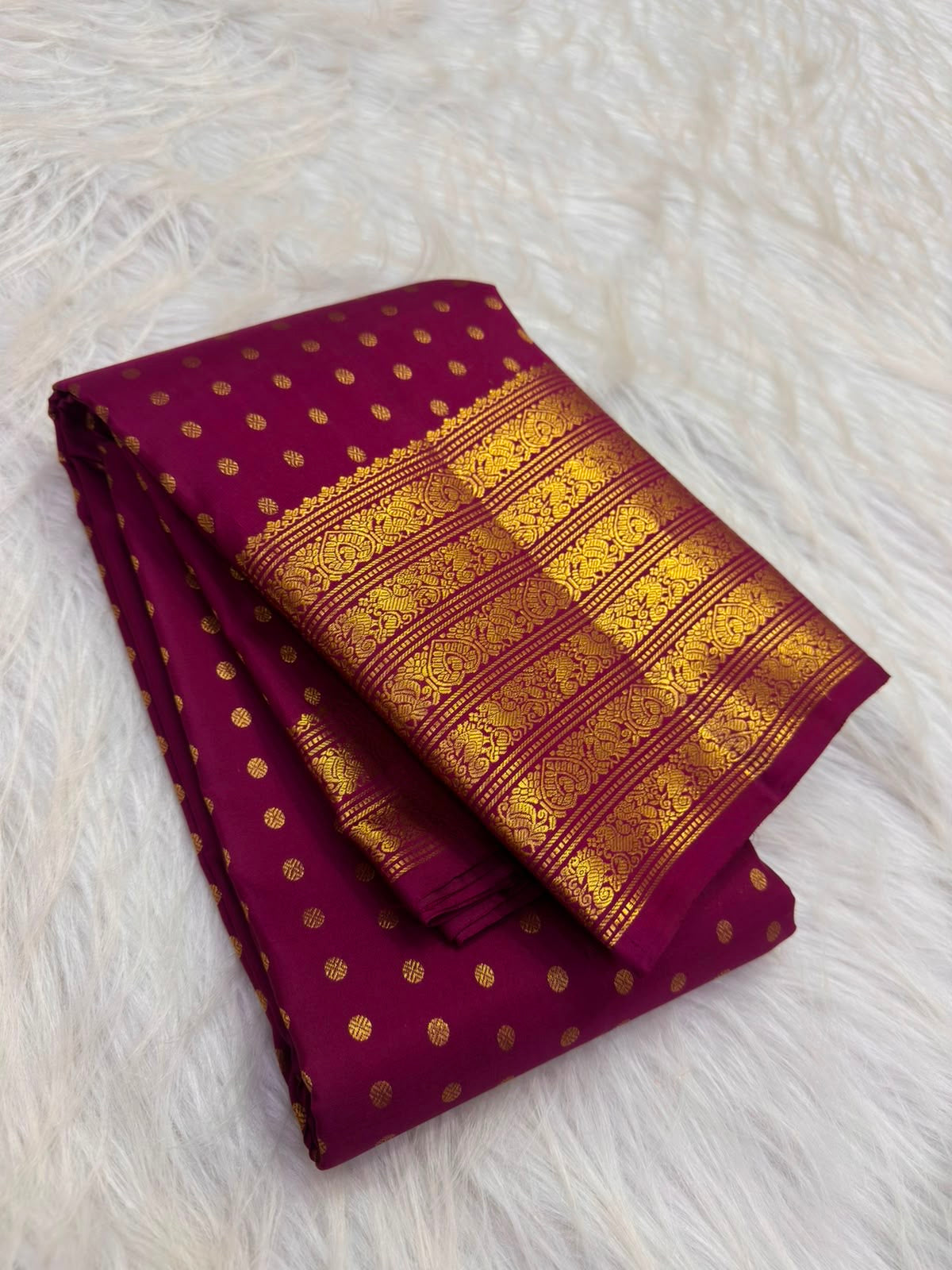 Close-up of stylised floral patterns and fine horizontal zari lines in a traditional Kanchipuram border.