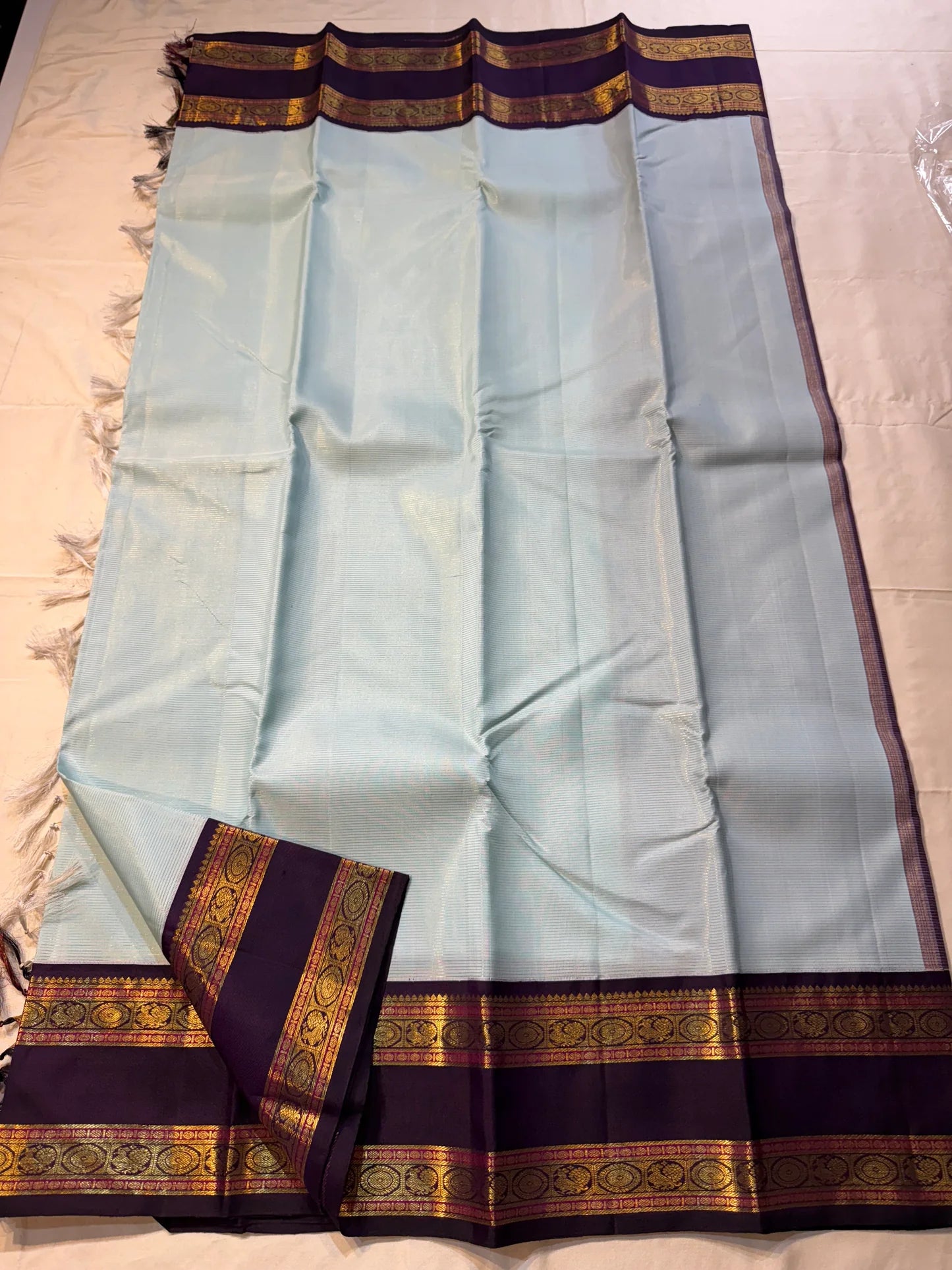 Neel Pushpa – Pure Kanchipuram Silk Saree
Pastel Powder Blue Vairaoosi Weave Body
Deep Violet Korvai Border with Zari Medallions
Antique Gold Zari Brocade Pallu, Diamond Jaal

Silk Mark Certified, delivery in 2 weeks