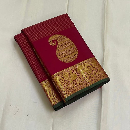 Ushas, Deep Arakku Red Pure Kanchipuram Silk Saree
Radiant Oosi Kattam body with ornate Paisley 2gm Zari
Vanasringaram,Muthuseer,Kamalam border with Fishpettu detailing
Exquisite diamond-pet grid Zari pallu, richly finished with a bold deep green selvedge