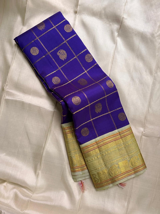 Amethyst Mayil Chakram – Pure Kanchipuram Silk Saree
Zari Kattam Checks with Peacock Motifs
Deep Violet Body with Golden Zari Detailing
Light Green Borders with Paisley Weaves

Silk Mark Certified, delivery in 2 weeks