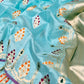 Close view of Aqua Blue handloom Chanderi silk with gold-toned motifs accented in magenta orange and green