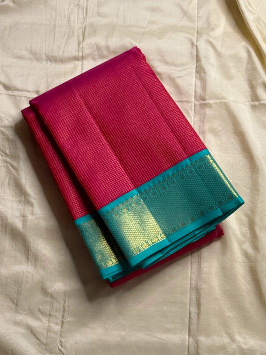 Leela Kattam — Kanchipuram Pure Silk

Rani-pink micro kattam body with soft vaira-oosi sheen

Contrast teal korvai borders with gold lattice & coin roundels

Rich teal pallu with all-over diamond/leaf zari jaal; rani tassels

Silk Mark Certified •