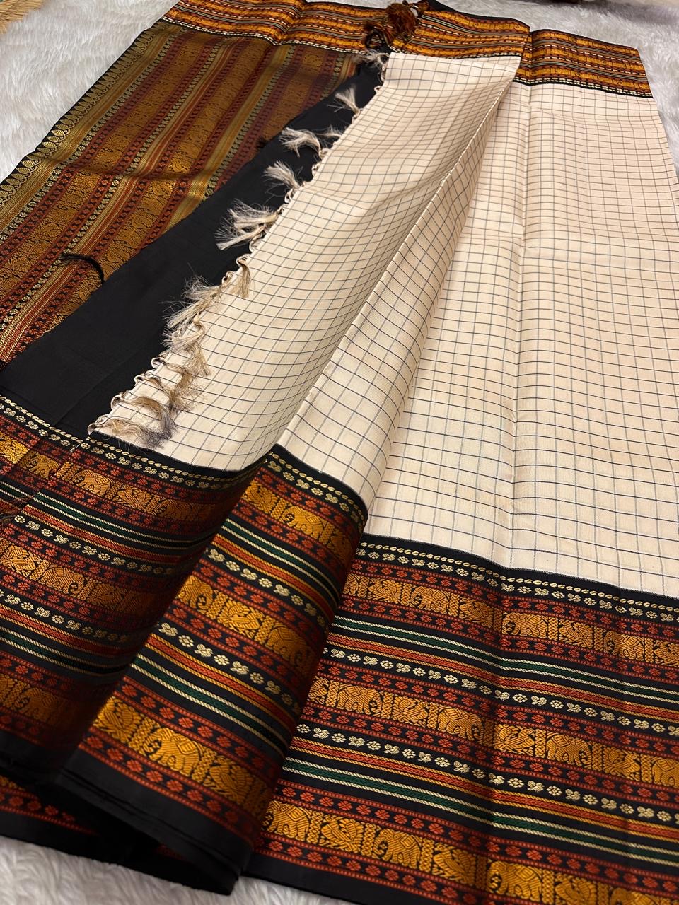 Ivory Varisaipet – Pure Kanchipuram Silk Saree
Pattunool Kattam Checks on Ivory Base
Black Borders with Elephant & Floral Motifs
Antique Gold, Rust & Bottle-Green Stripes

Silk Mark Certified, delivery in 2 weeks