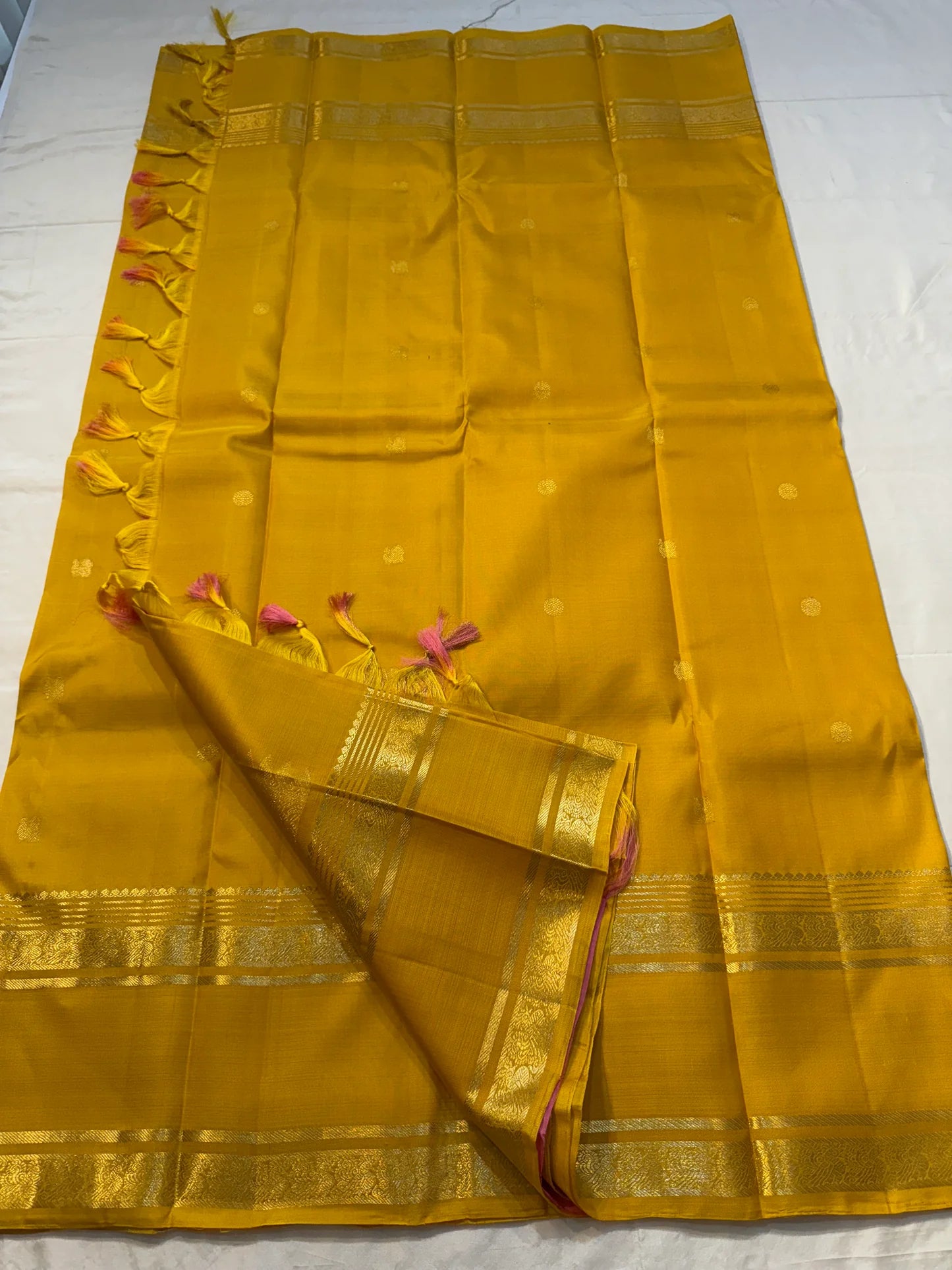 Kanakam mellow yellow body with zari rosette buttas and antique-gold borders; intricate pallu in diamond brocade with tassels.rose pink blouse 
Silk Mark Certified • Free Shipping within USA • Ships in Two Weeks ✅
