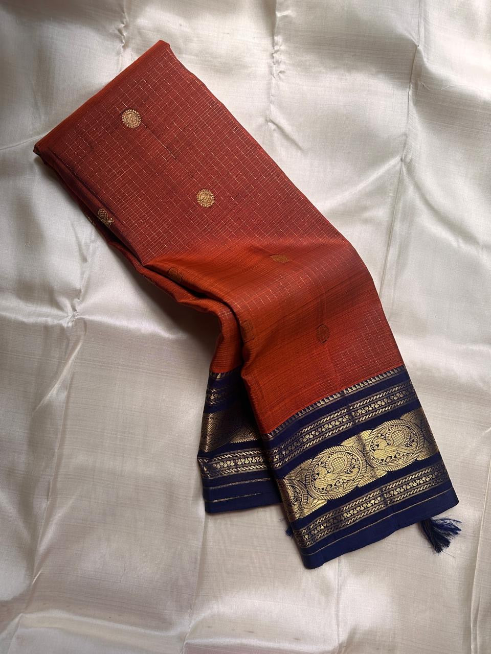 Rust Orange Sorgavasal Mayil – Pure Kanchipuram Silk Saree
Rust Orange Body with Petite Gold Zari Buttas ✨
Grand Navy Border with Sorgavasal mayil Peacock Motifs 🦚
Contrast Pallu in Rich Zari Weave 💫
Silk Mark Certified, delivery in 2 weeks